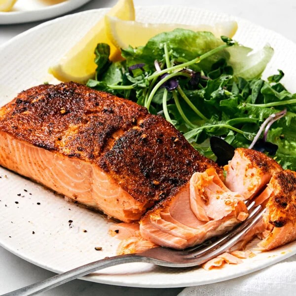 A plate of air fryer salmon and leafy greens.