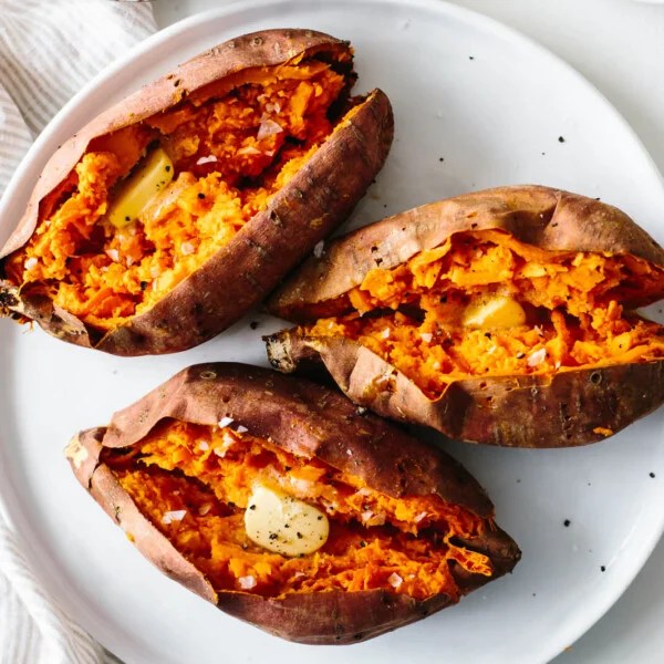 Baked sweet potato on a white plate.