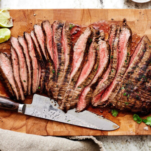 Sliced carne asada on a wooden board