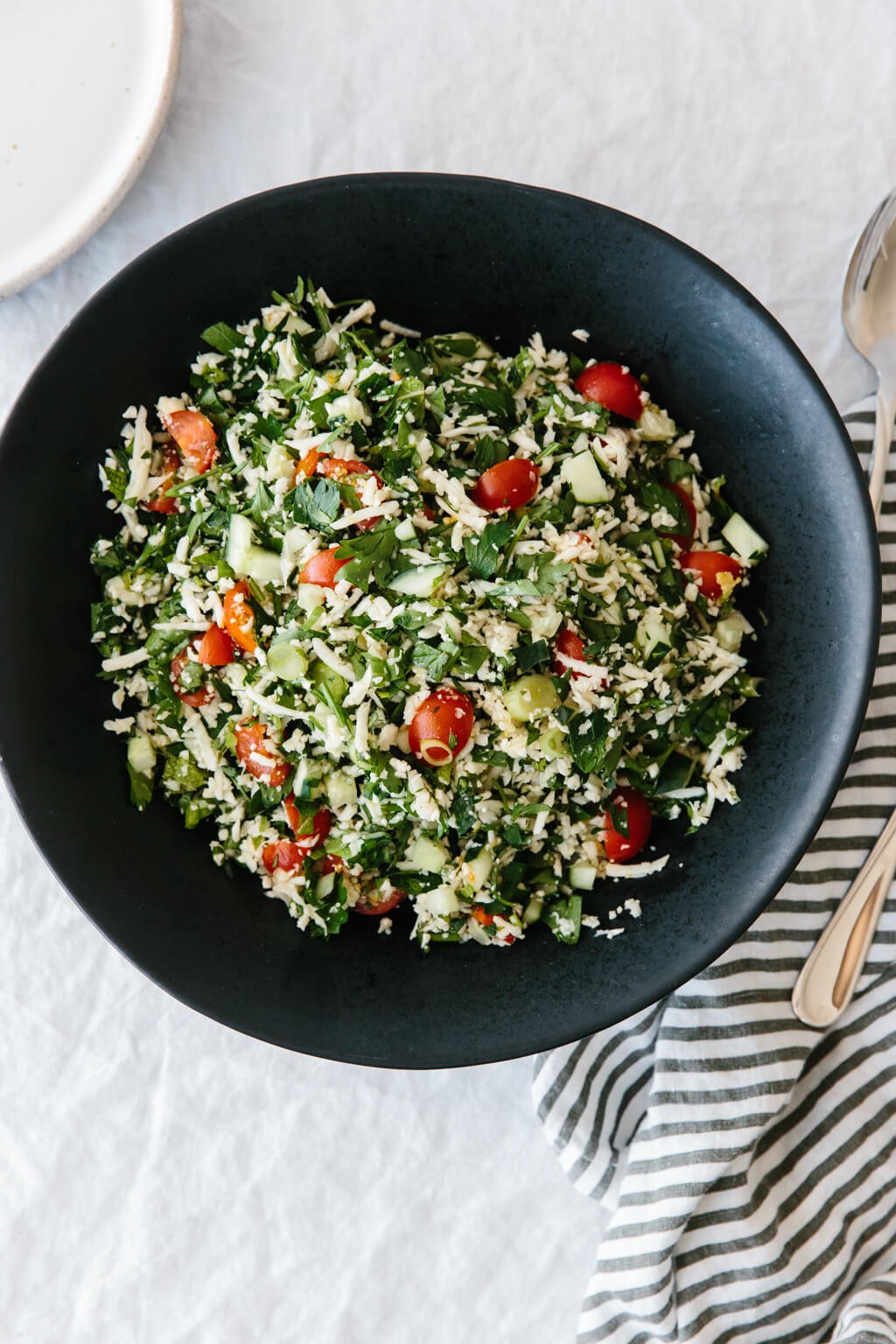 (gluten-free, paleo, whole30) Cauliflower rice tabbouleh is a tasty spin on tabbouleh and swaps bulgur with cauliflower rice, making this lemon herb salad gluten-free and paleo-friendly.