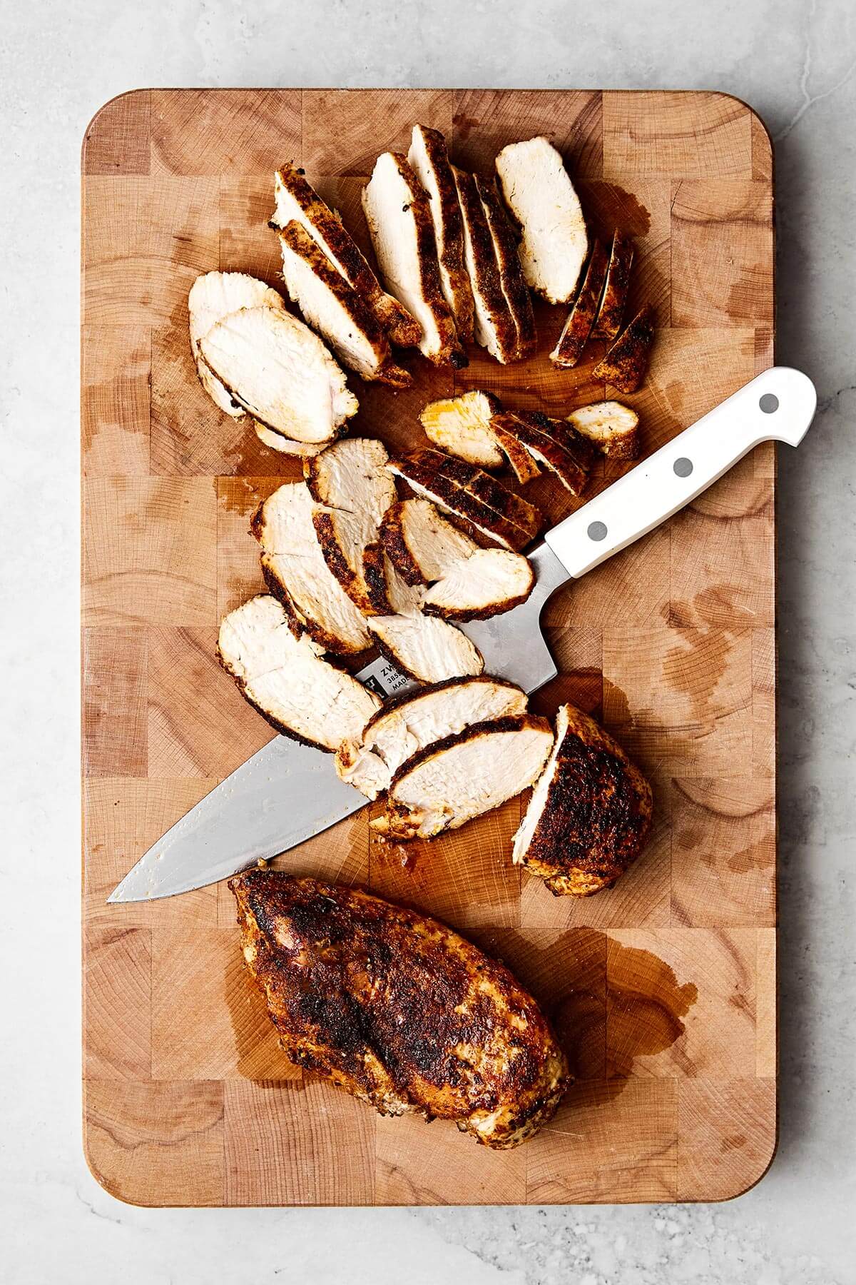 Sliced chicken breast on a wooden board.