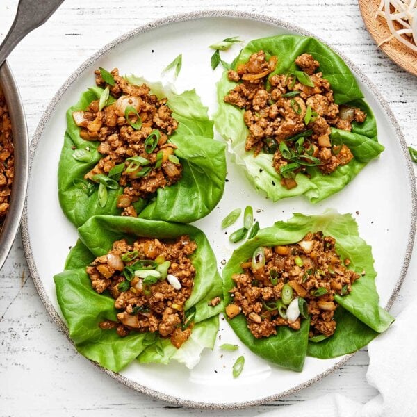 A white plate of chicken lettuce wraps.