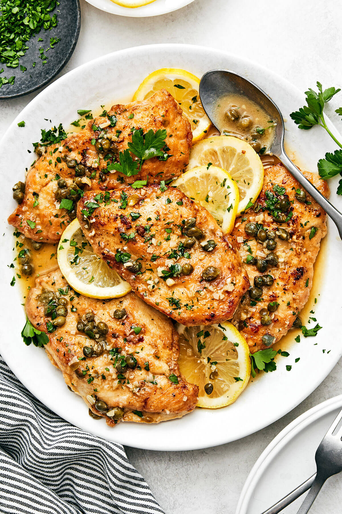 Chicken piccata in a white serving dish