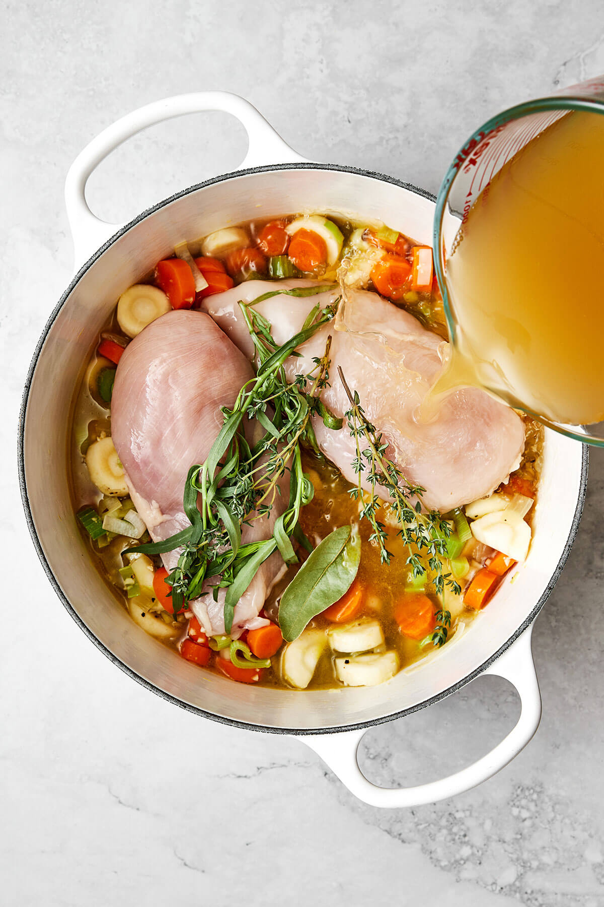 Cooking chicken breast and vegetables in a pot.