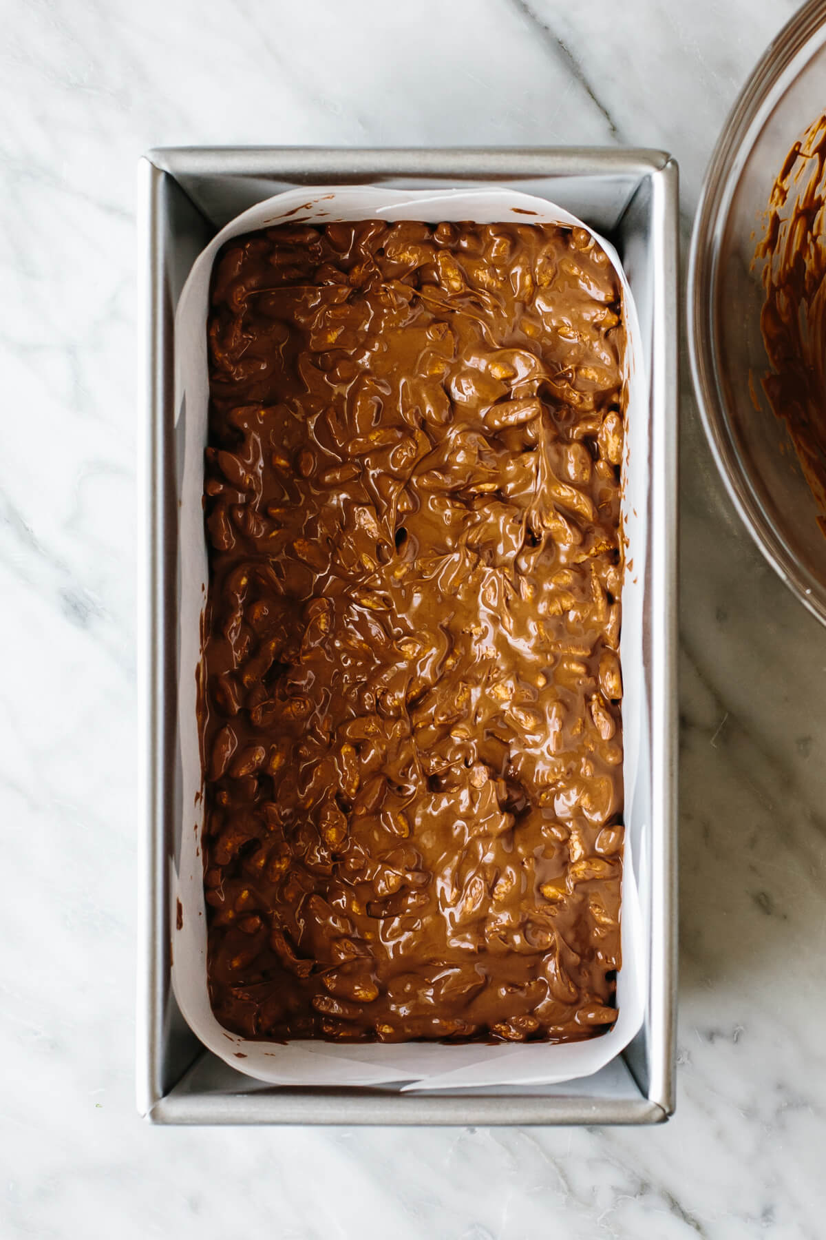 Making chocolate crunch bars in a loaf pan.