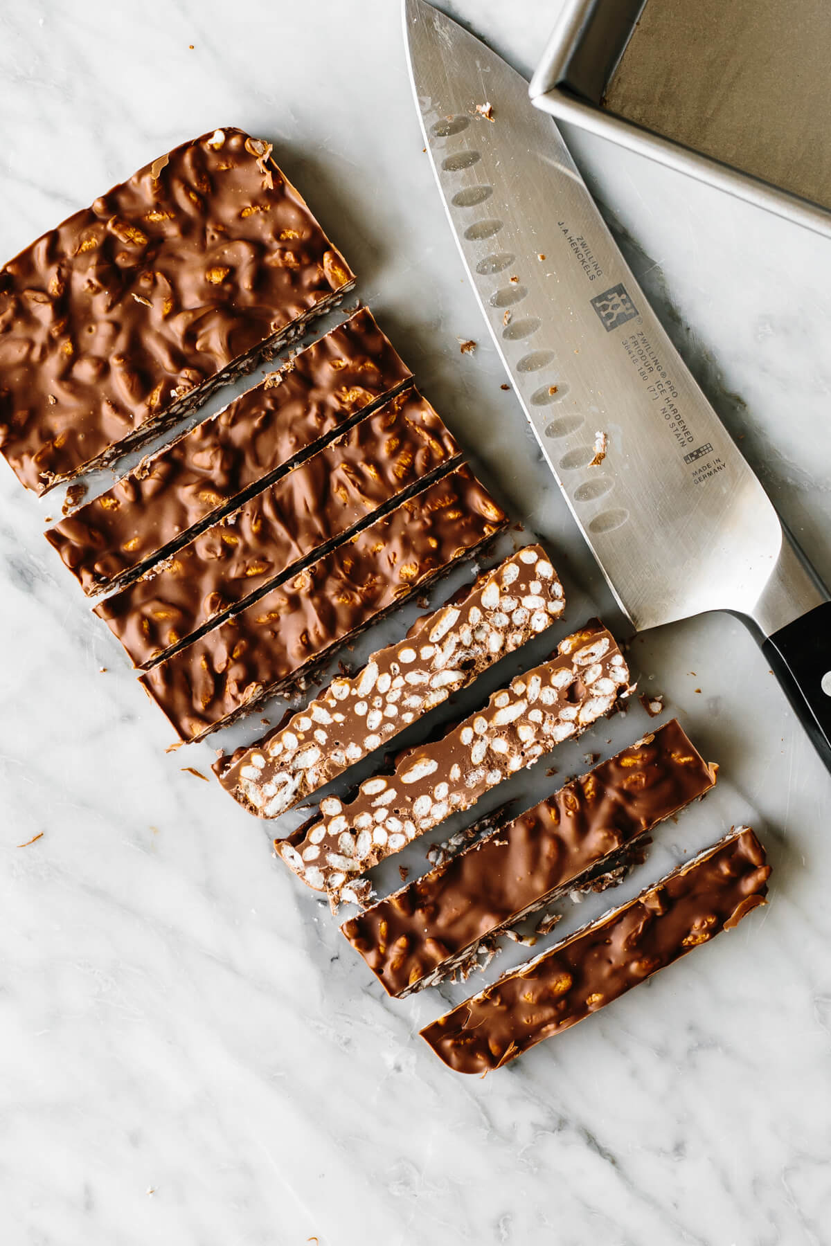 Chocolate crunch bars on a table next to a knife.