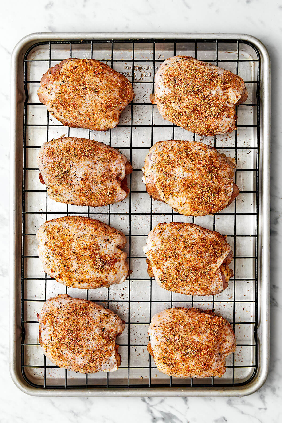 Chicken thighs on a baking sheet.