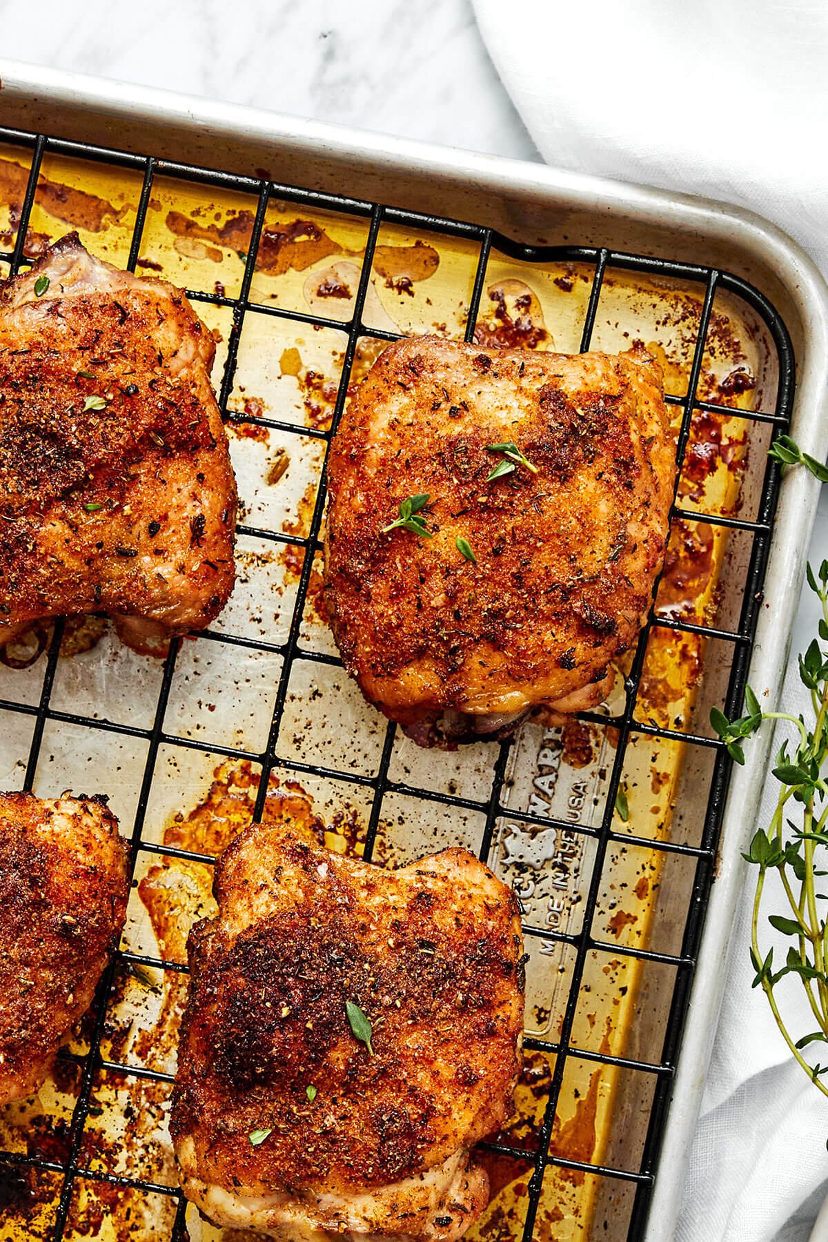 Crispy baked chicken thighs on a baking sheet.