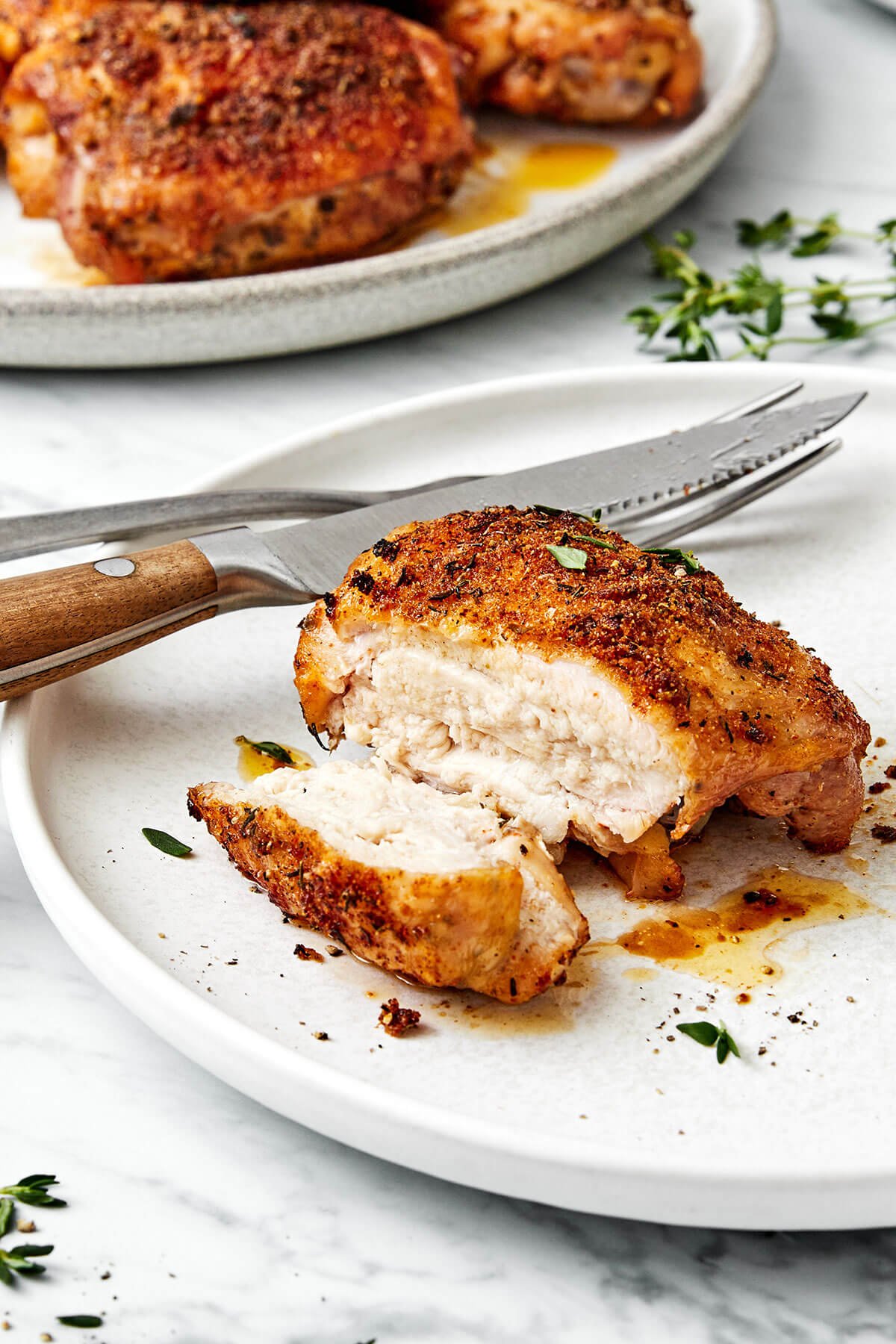 A baked chicken thigh on a plate.