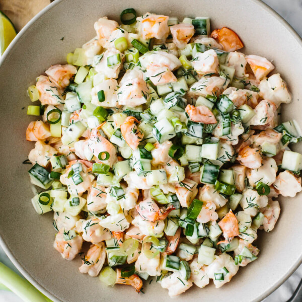 A large serving bowl of cucumber shrimp salad