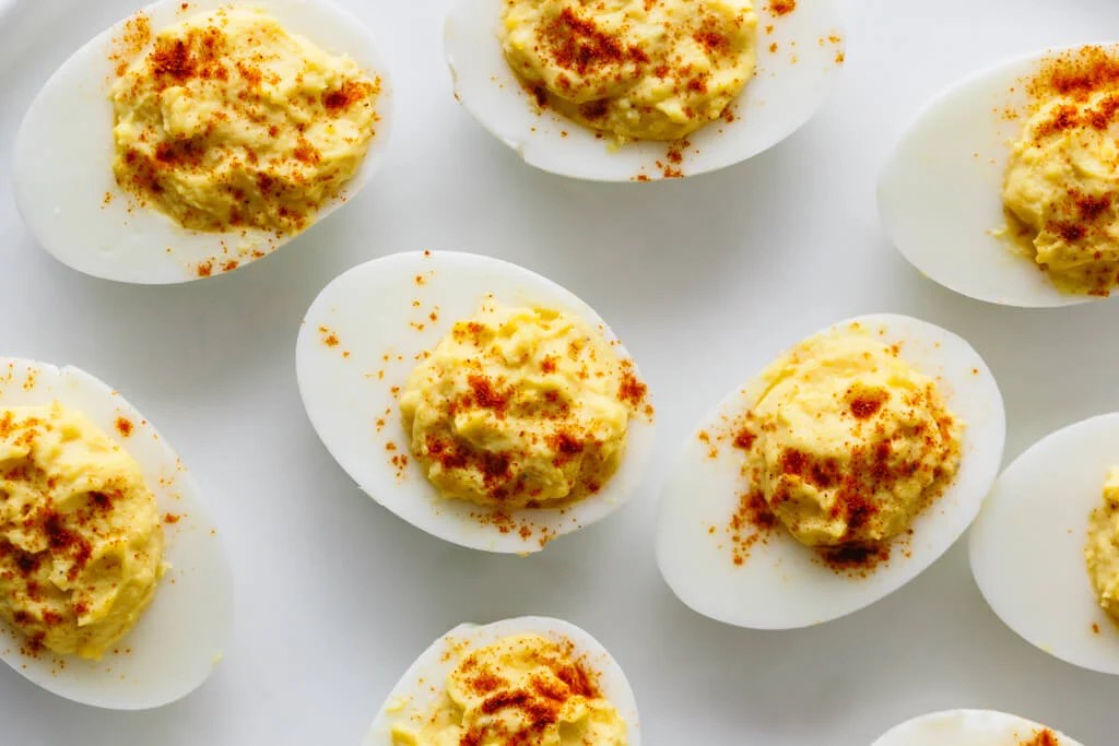 Deviled eggs are hard boiled eggs where the yolk is mixed with mayonnaise, mustard, vinegar, salt and pepper. A little sprinkle of paprika on top helps make these the best deviled eggs recipe.