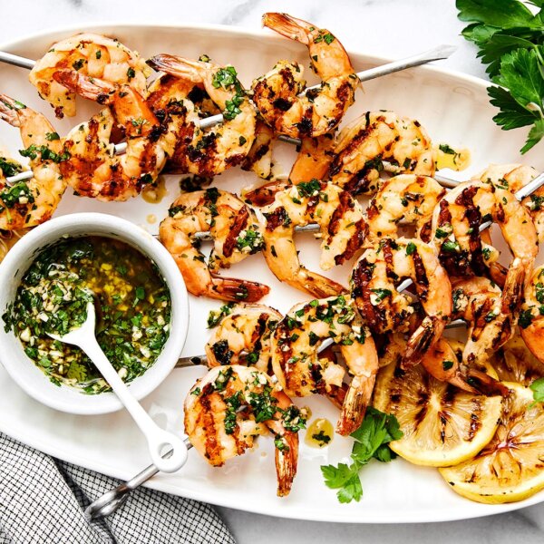 A white plate with grilled shrimp.