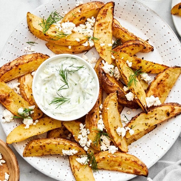 A plate of Greek fries with feta and tzatziki.