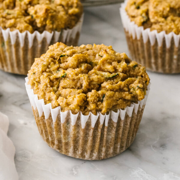 A few healthy zucchini muffins next to a napkin.