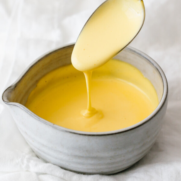 Hollandaise sauce dripping off a spoon.