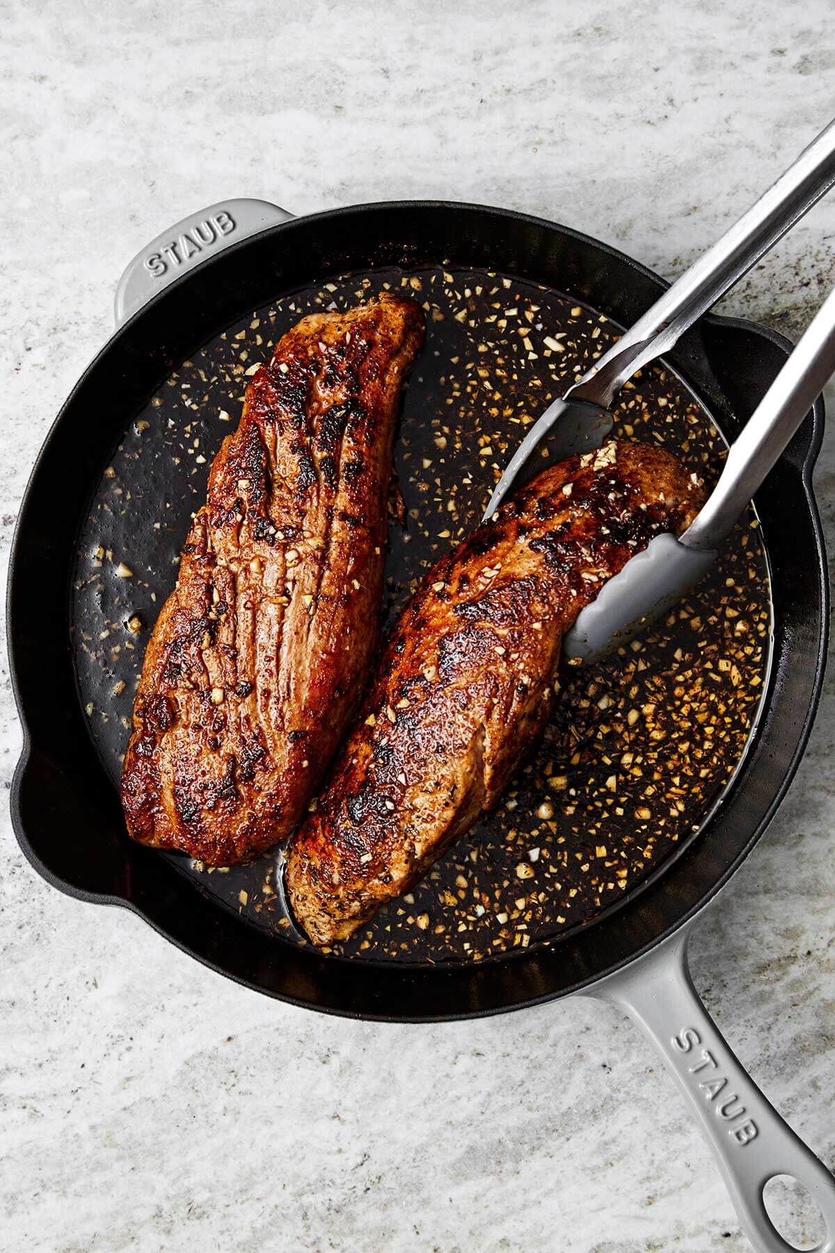 Cooked pork tenderloin in a pan.