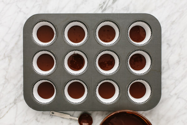 Melted chocolate in muffin tin for almond butter cups.