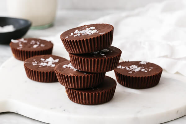 A white board with almond butter cups on top.