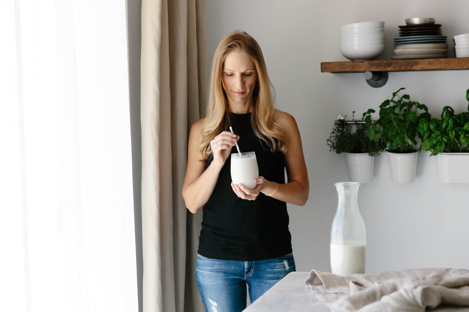 Girl standing and drinking cashew milk