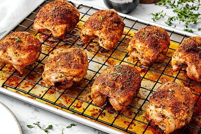 Crispy baked chicken thighs on a sheet pan.