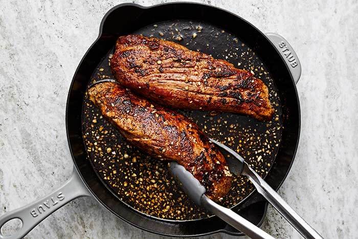 Cooking pork tenderloin in sauce.