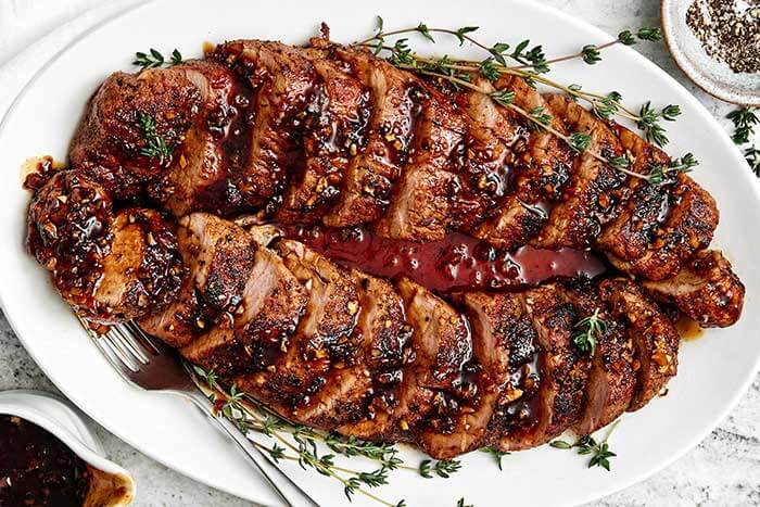 Pork tenderloin on a white plate.