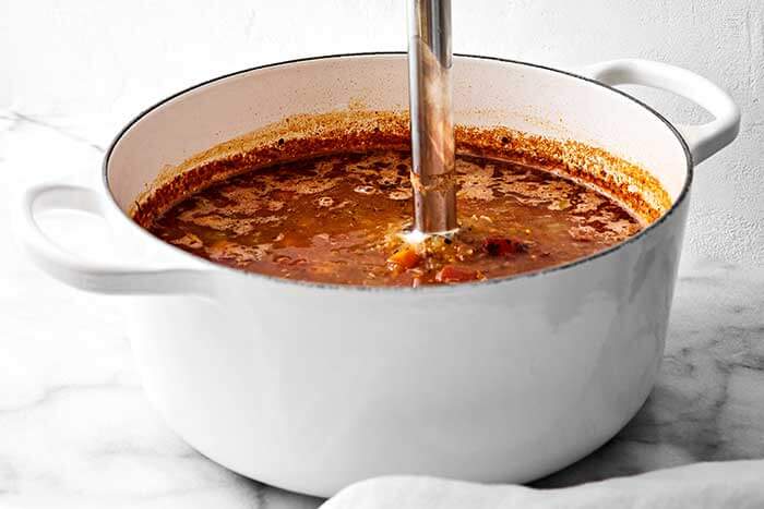 Blending lentil soup in a pot.