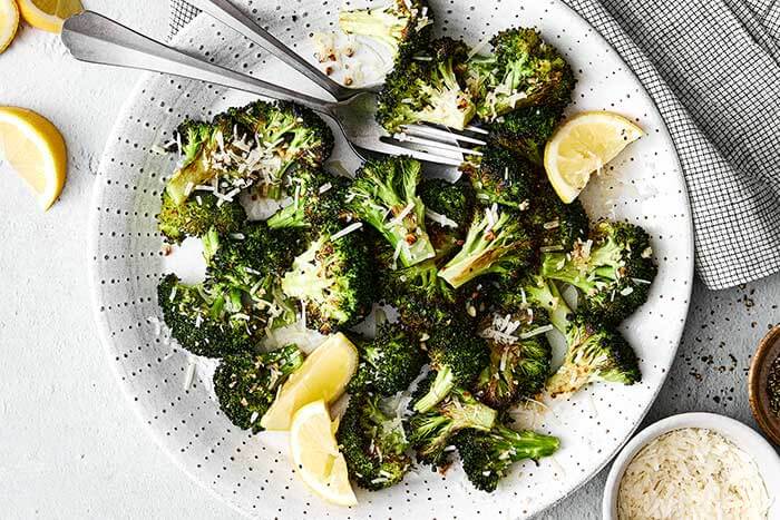 Roasted broccoli with lemon wedges.