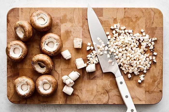 Chopped mushrooms on a wooden board.