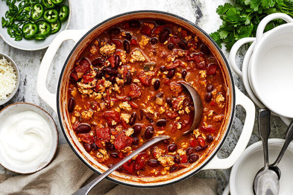 A large pot of turkey chili with a ladel