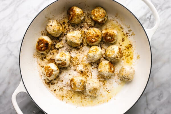 Cooking turkey meatballs in a large pan