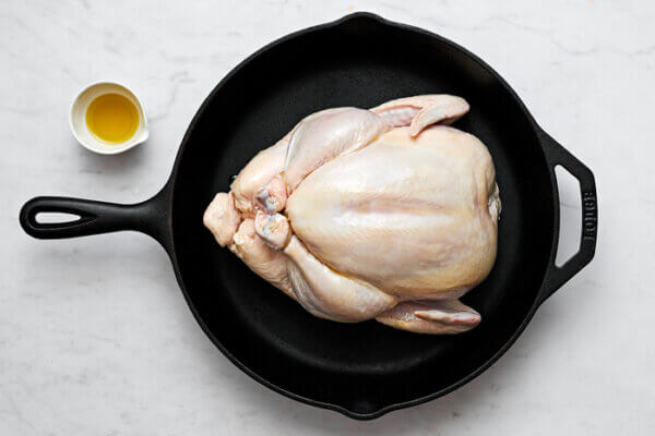 Olive oil on roast chicken in a pan