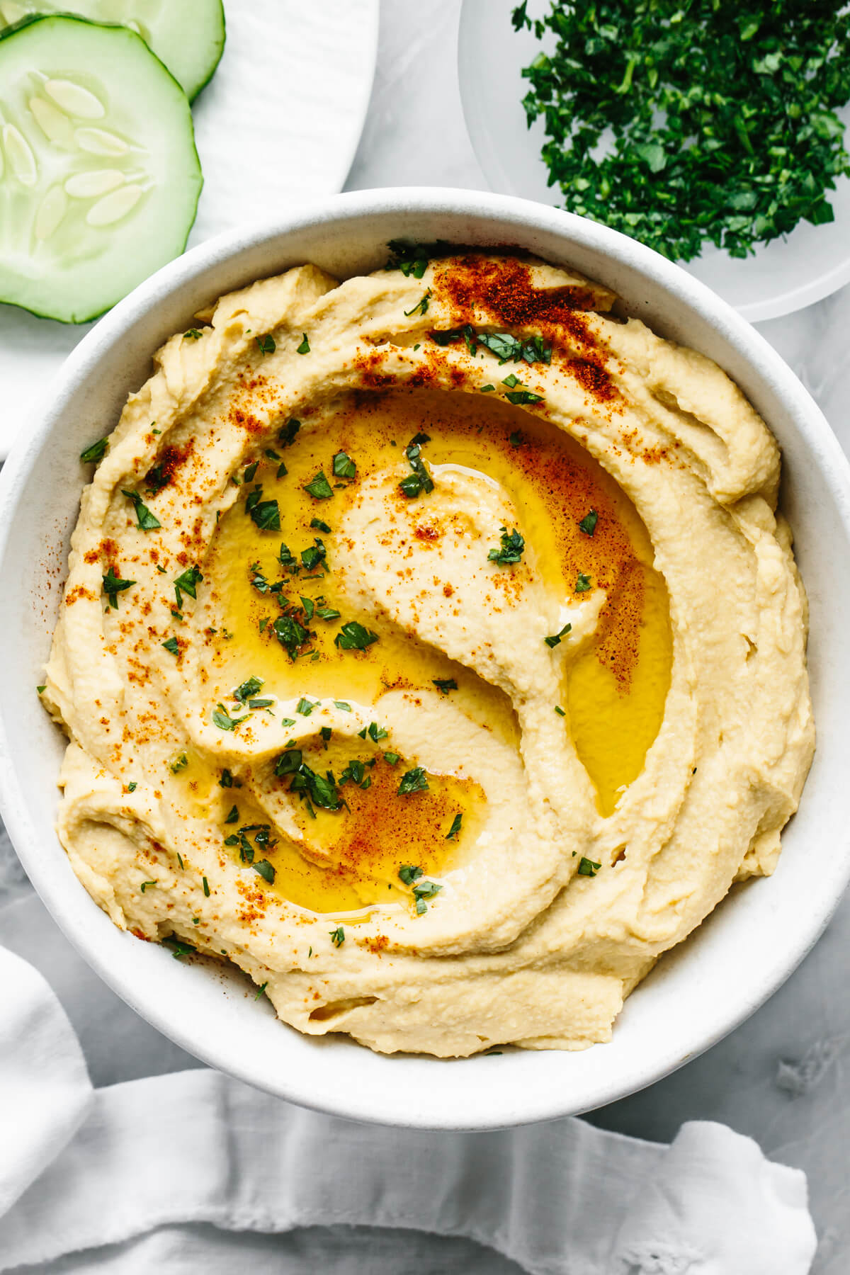 A bowl of homemade hummus next to a napkin