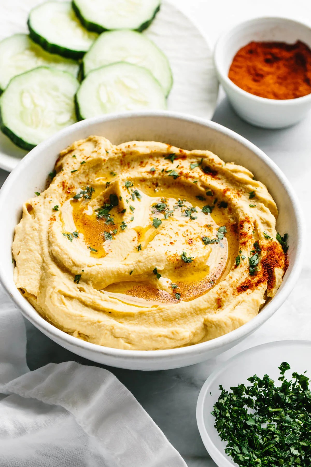 A bowl of hummus next to paprika