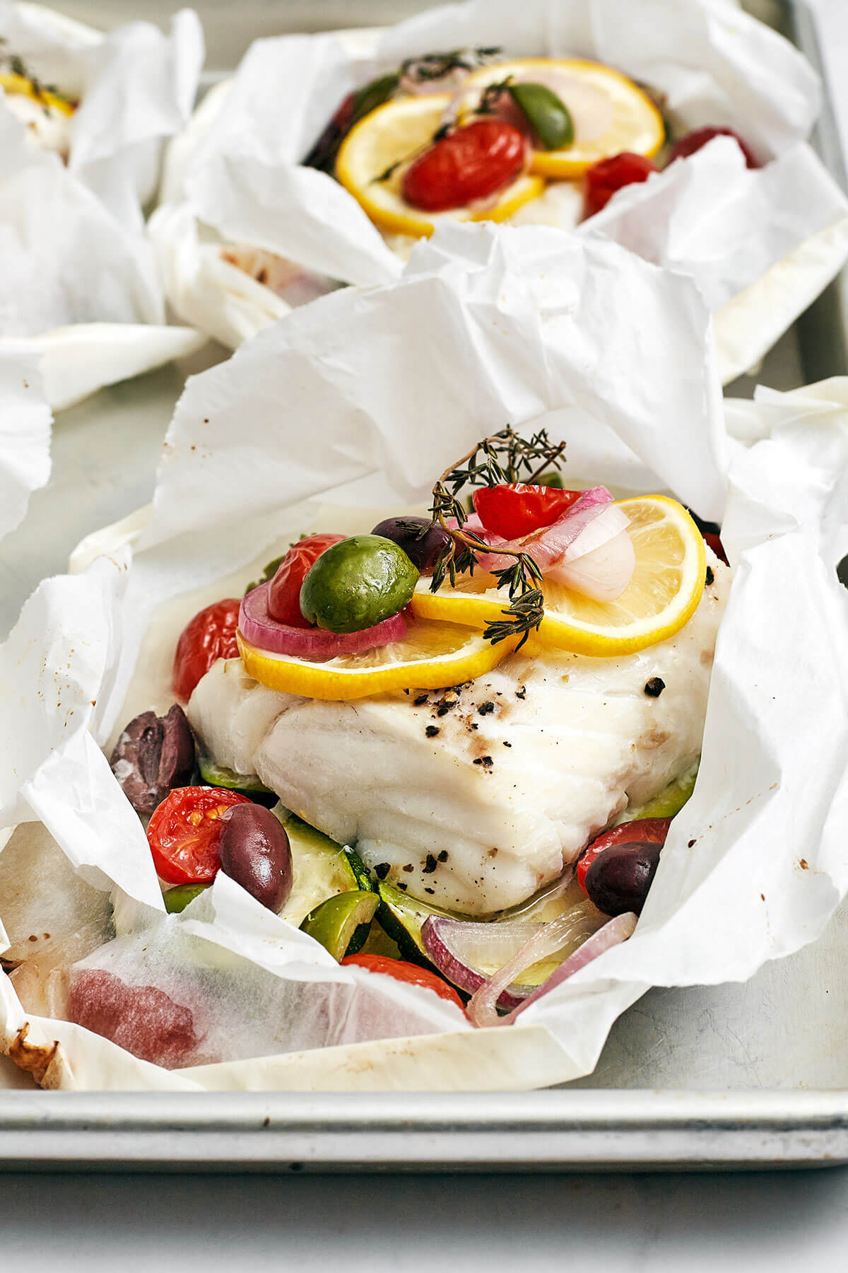 Mediterranean cod en papillote on a baking sheet