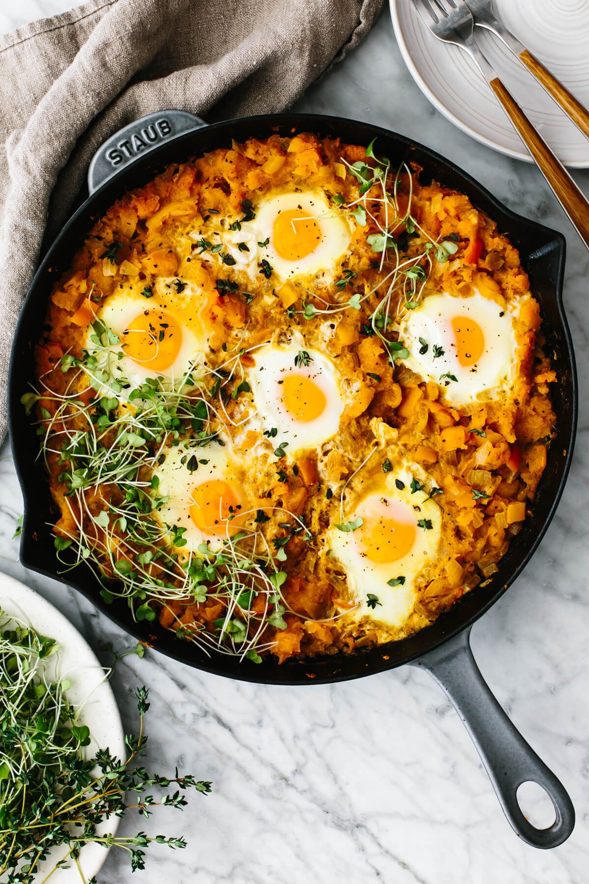 Orange shakshuka in a skillet on a table.