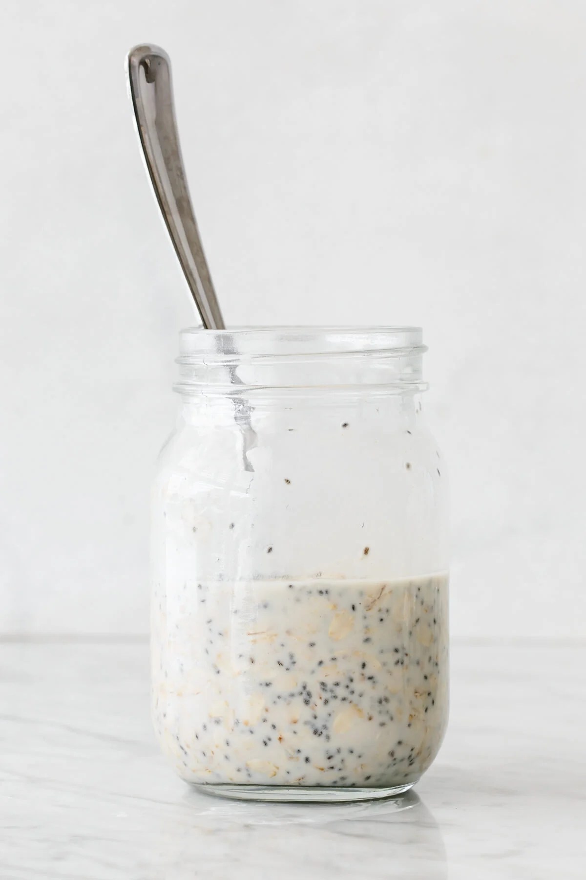 Stirred overnight oats in a jar with spoon.