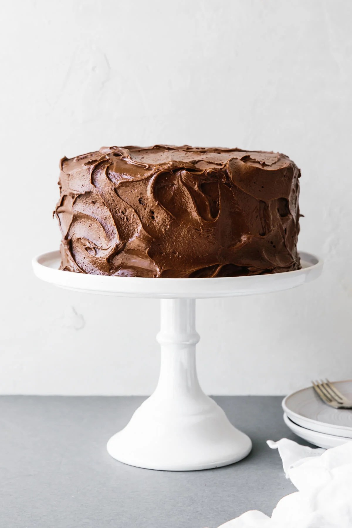 Paleo chocolate cake on a white cake stand.