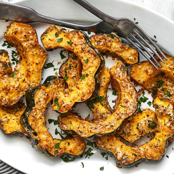 Parmesan herb roasted acorn squash on a white plate with forks