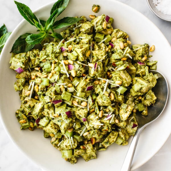 A white bowl of pesto chicken salad