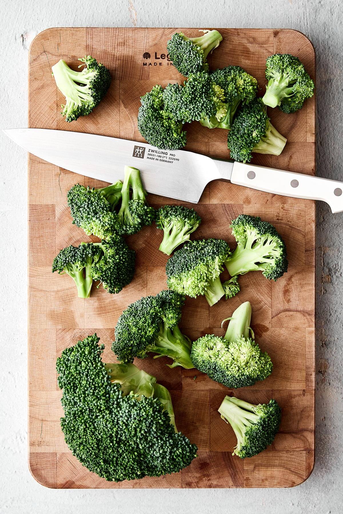 Sliced broccoli on a wooden board.