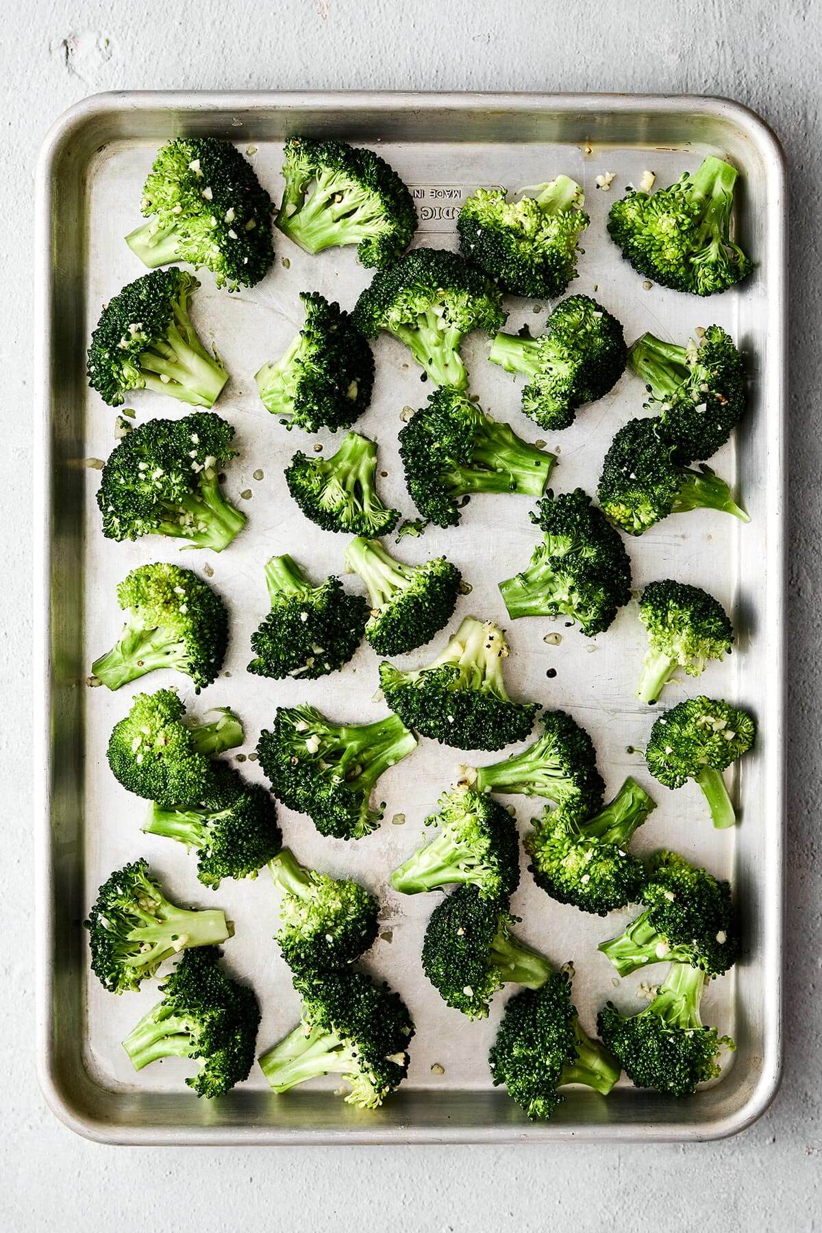 A sheet pan with broccoli florets.