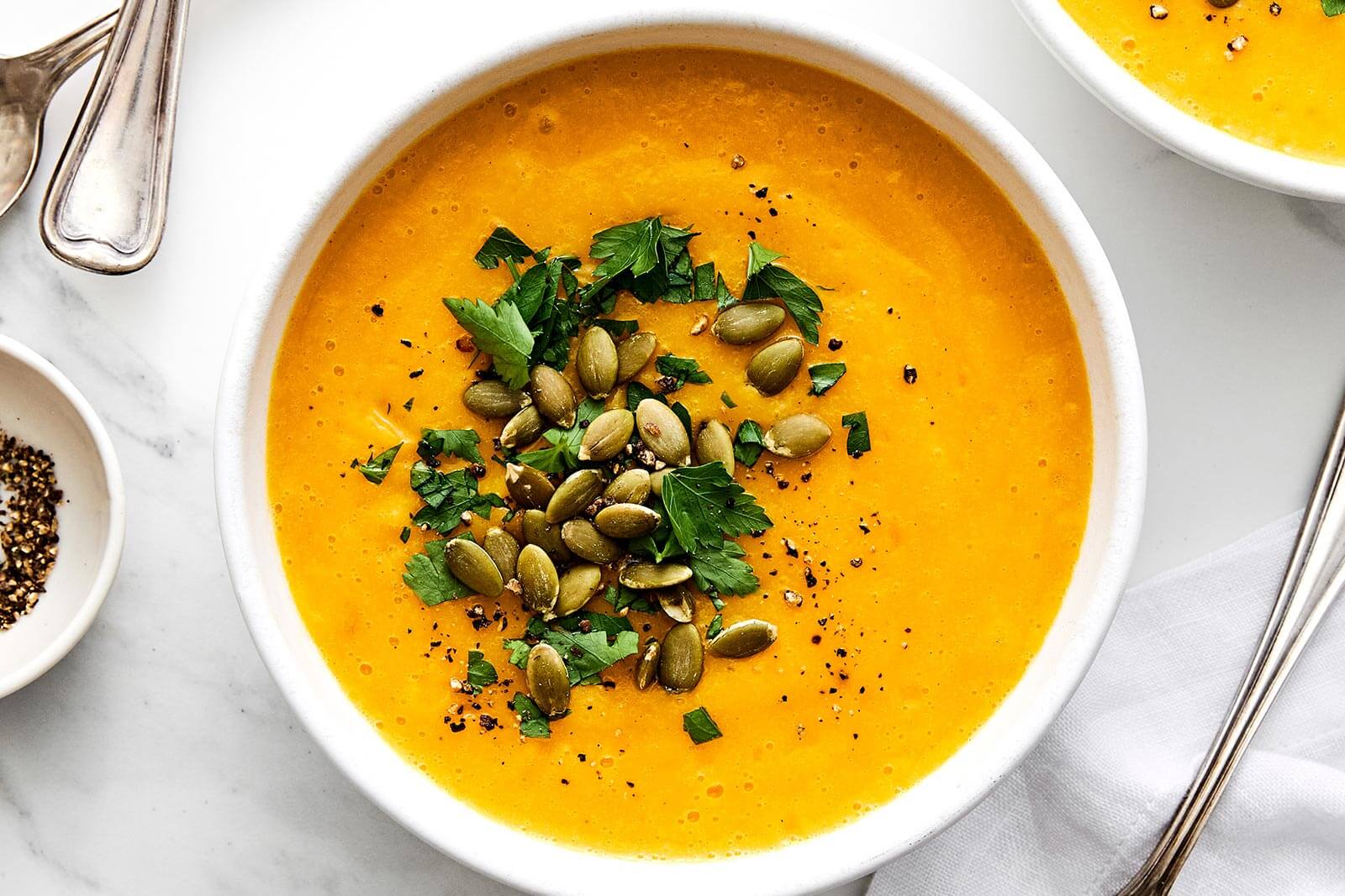 A white bowl of roasted butternut squash soup.