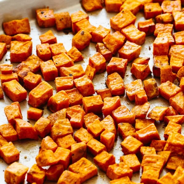 Roasted sweet potatoes on a sheet pan.