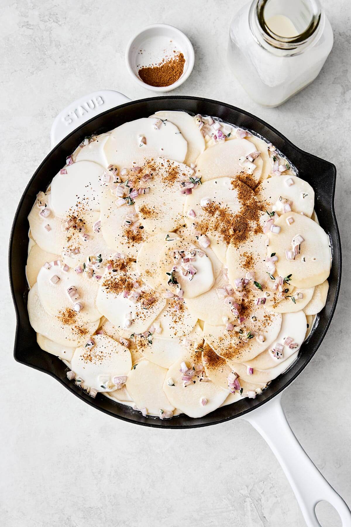 Layering scalloped potatoes in a pan.