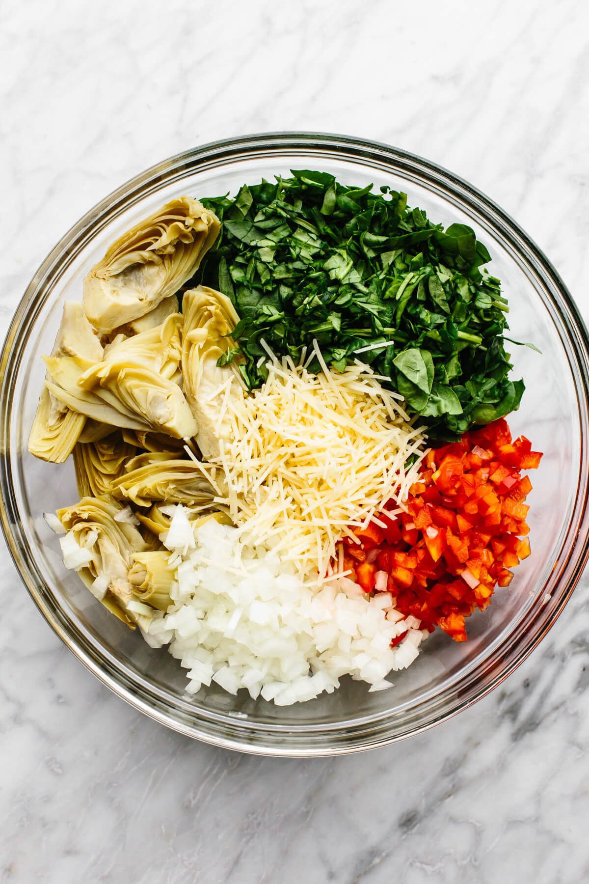 A bowl of spinach artichoke chicken bake ingredients