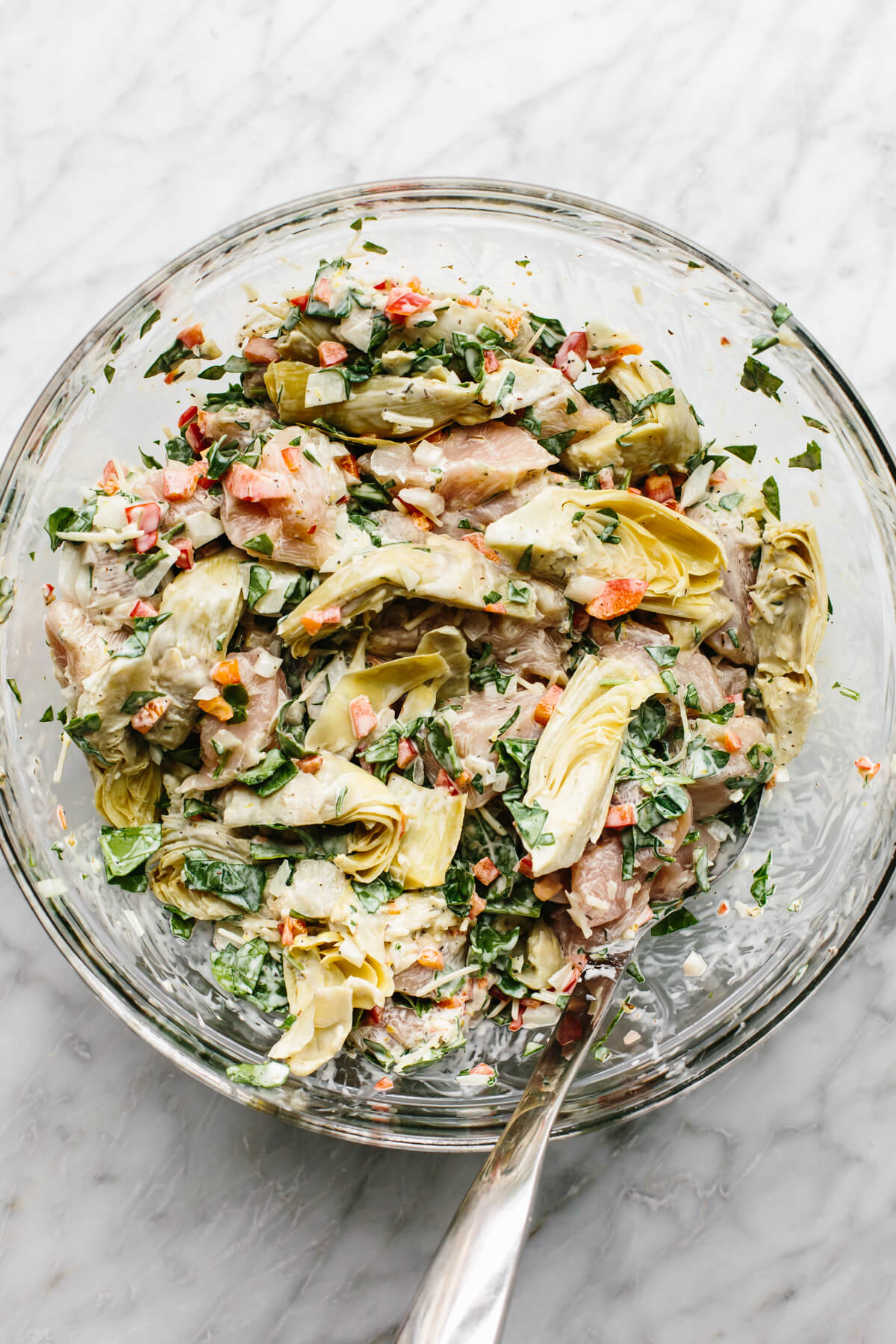 Spinach artichoke chicken bake ingredients mixed in a bowl