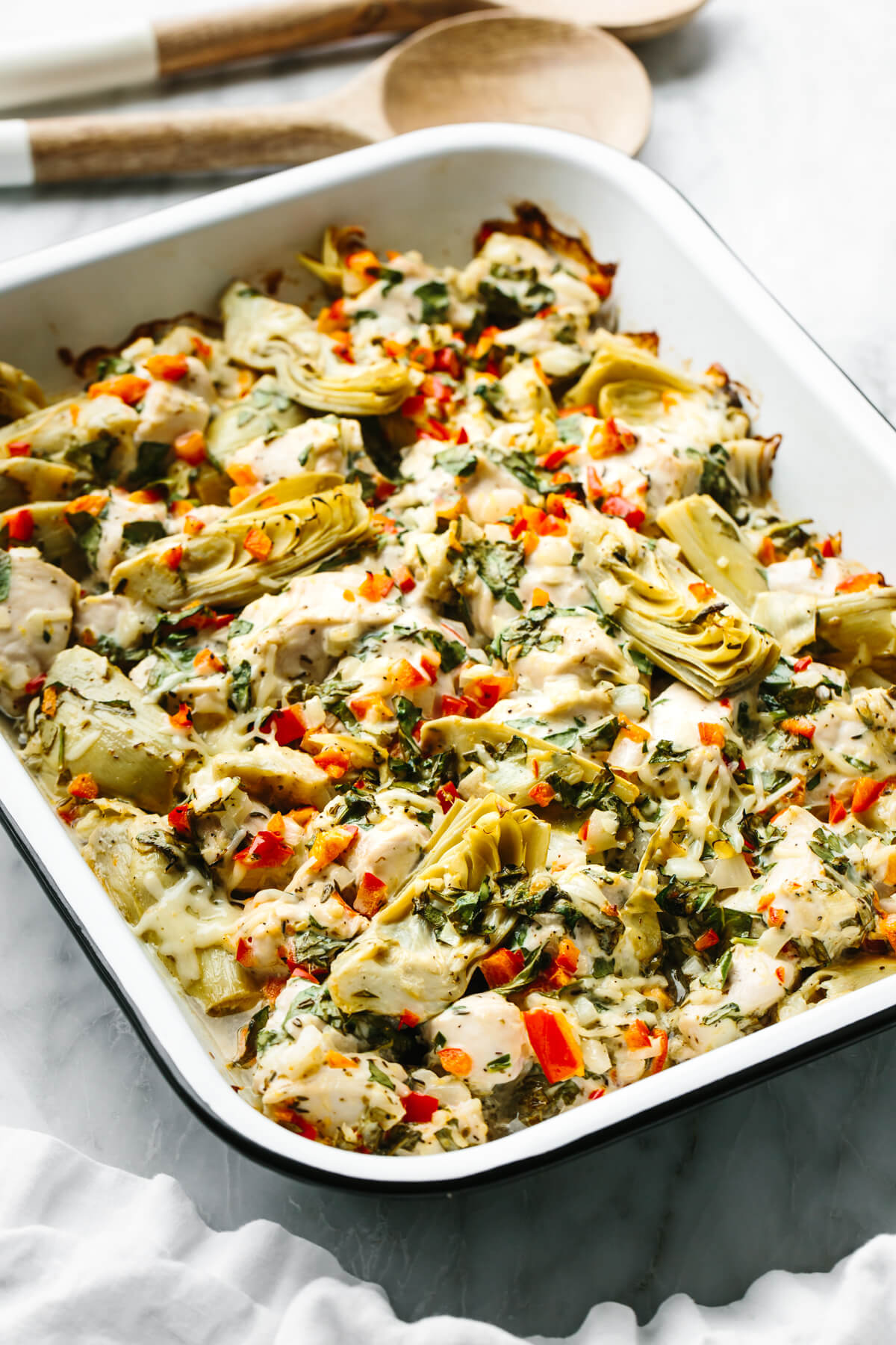 A casserole pan with spinach artichoke chicken bake