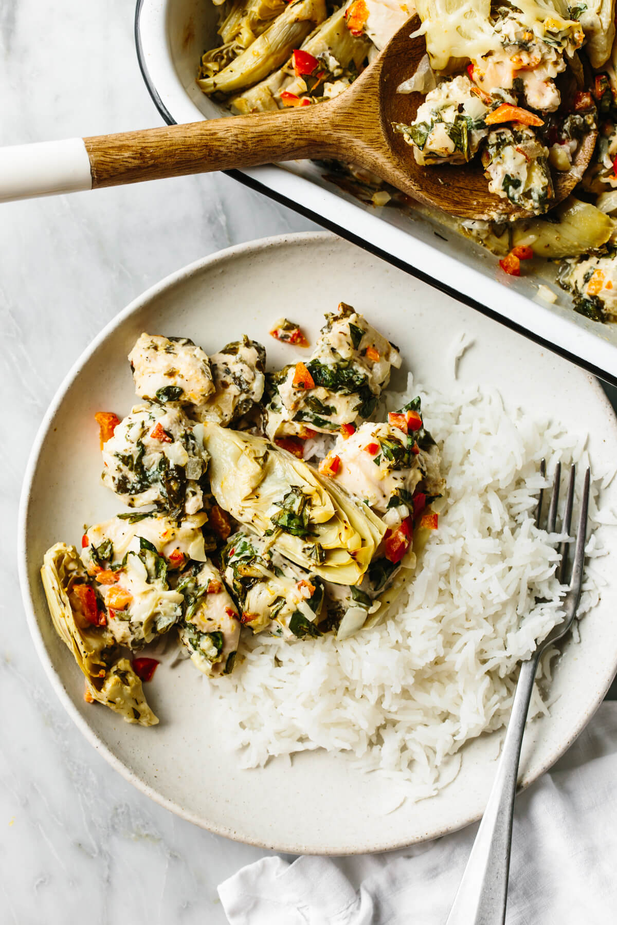 A plate of rice and spinach artichoke chicken bake