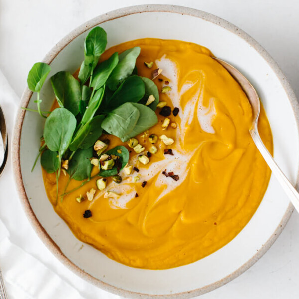 Sweet potato soup in a white bowl with a spoon.